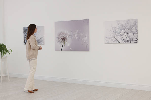 istock Woman studying beautiful artwork in modern gallery 2214460627