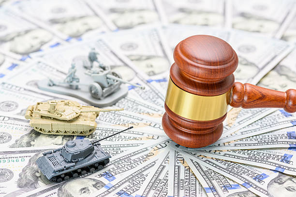 Trade war, import tariffs, global power dynamics : Military models and legal authority symbols on U.S. dollars highlight the interplay of economic, military, amidst escalating geopolitical tensions.