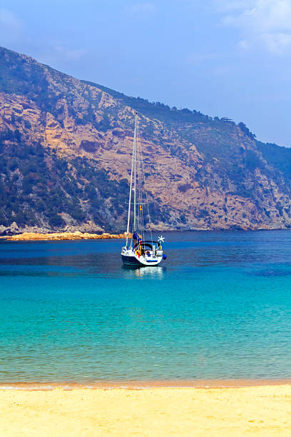 White sailing boat and blue sea seen from Aiguablava beach, Begur, Costa Brava, Girona.Spain.