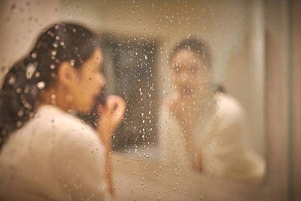 istock Beautiful Female Applying Makeup at Bathroom 2214470177