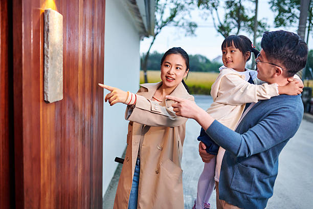 Side view of asian family talking and standing at hostel entering.