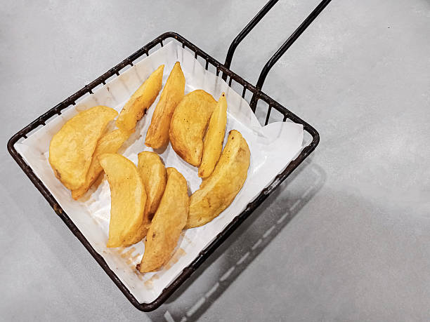 Fried potato wedges in an iron basket