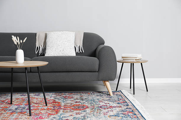 istock Comfortable sofa and tables near grey wall in room 2214477152