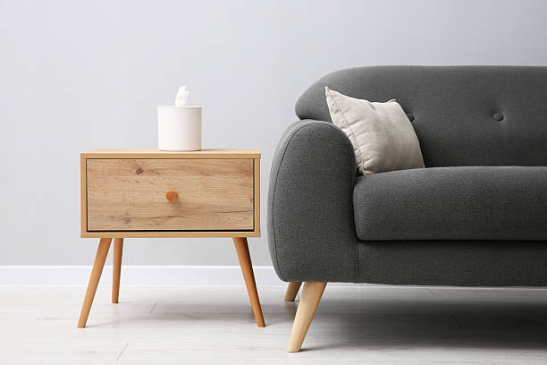 istock Comfortable sofa and table near grey wall in room 2214477201