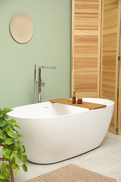 istock Stylish bathroom interior with folding screen and tub 2214477251