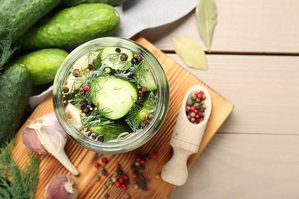 istock Making pickles. Fresh cucumbers and spices in jar on wooden table, top view 2214477607