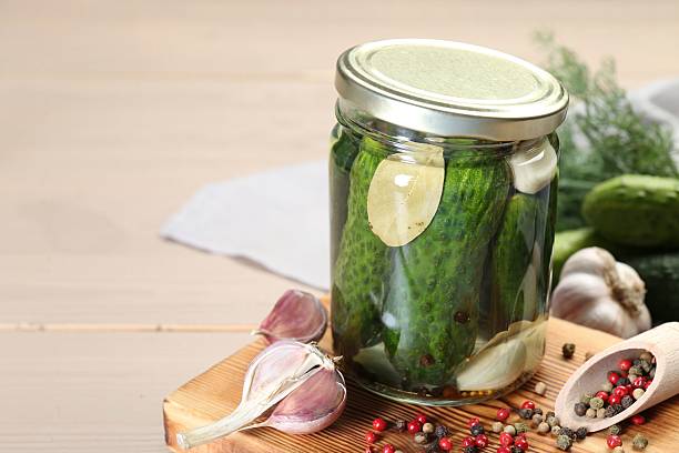 istock Making pickles. Fresh cucumbers and spices in jar on wooden table, closeup. Space for text 2214477608