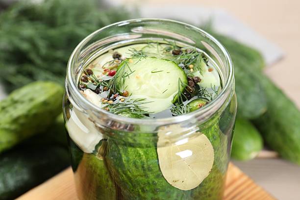 istock Making pickles. Fresh cucumbers and spices in jar on wooden table, closeup 2214477613