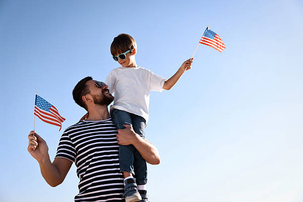 istock Happy father and son with flags of USA outdoors. Space for text 2214481011
