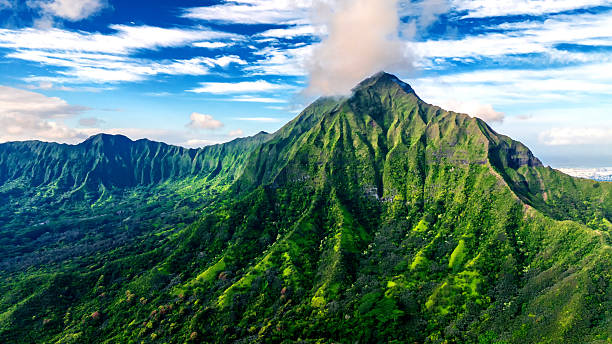 istock Approaching a sharp peak of the verdant mountain. Azure sky with light clouds at backdrop. 2214482834