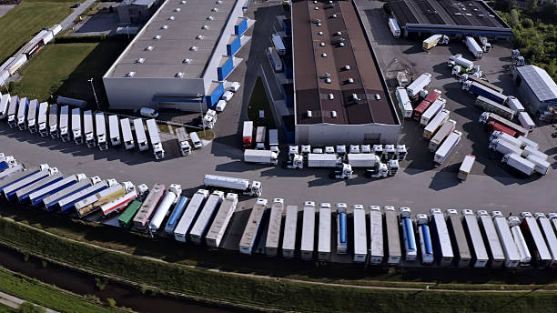 istock Trucks parked in a large lot near a warehouse. 2214484445