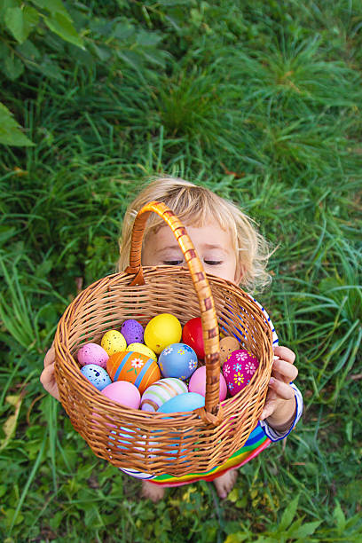 A child collects Easter eggs in the grass. Selective focus. Kid.
