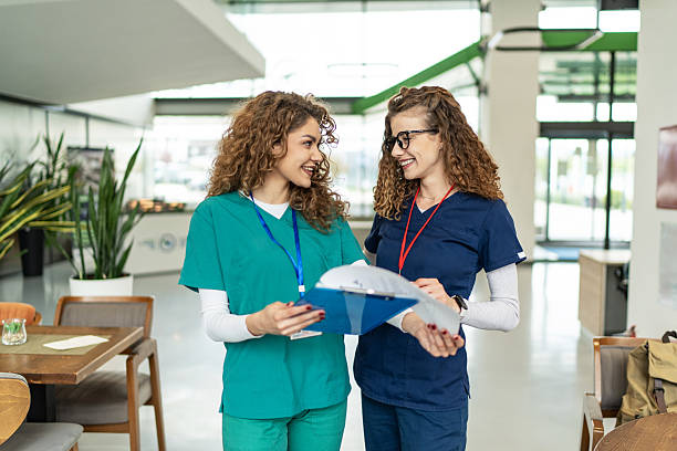 istock Two young nurses discussing medical records in hospital cafeteria 2214488280