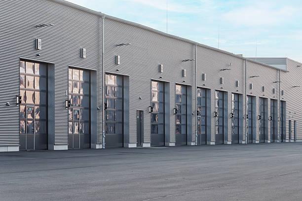 istock Modern industrial building with large numbered glass garage doors and visible interior storage 2214492072