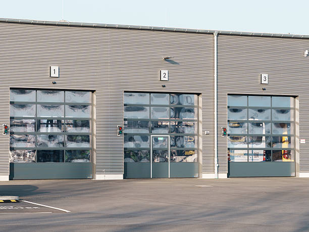 istock Modern industrial building with large numbered glass garage doors and visible interior storage 2214492087