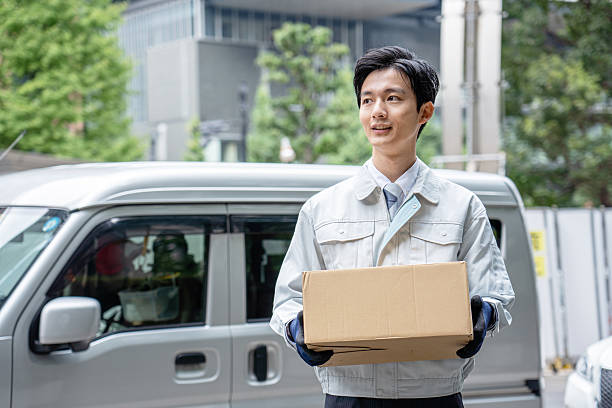 istock A man in work clothes holding a cardboard box 2214492875