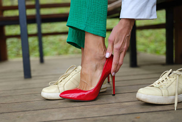 istock woman changes sneakers into shoes 2214497265