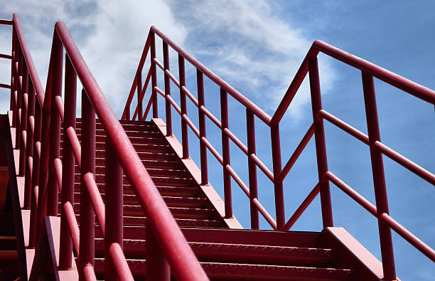 istock A set of stairs ascending a large red wall 2214497864