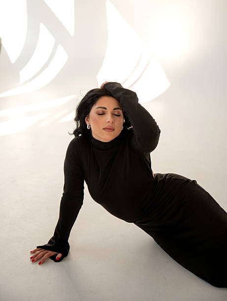 istock Brunette in a black dress on the floor in sunlight 2214498049