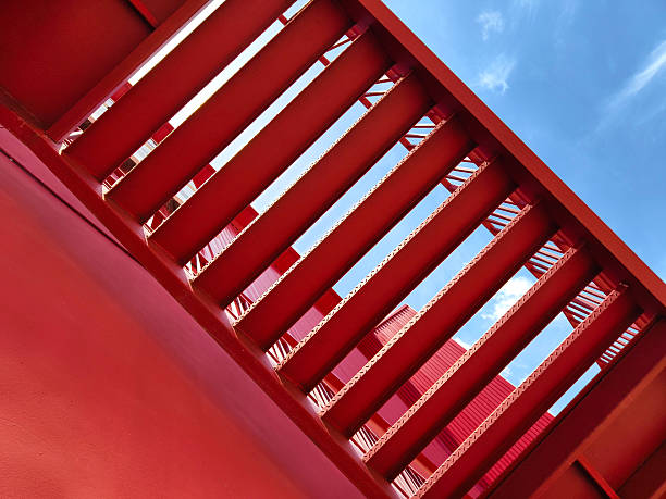 istock A set of stairs ascending a large red wall 2214498343