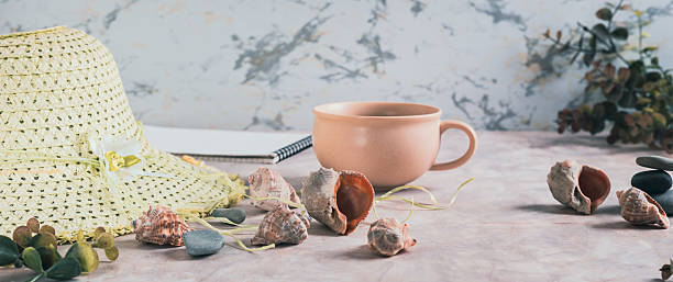 Travel background, hat, shells, stones and cup of coffee on table web banner
