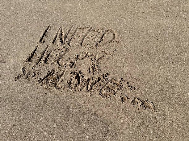 istock in a sand  beach the words i need help so alone are written 2214501176