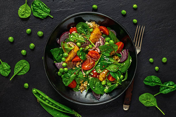 istock Healthy vegan salad with spinach tomatoes and peas 2214502563