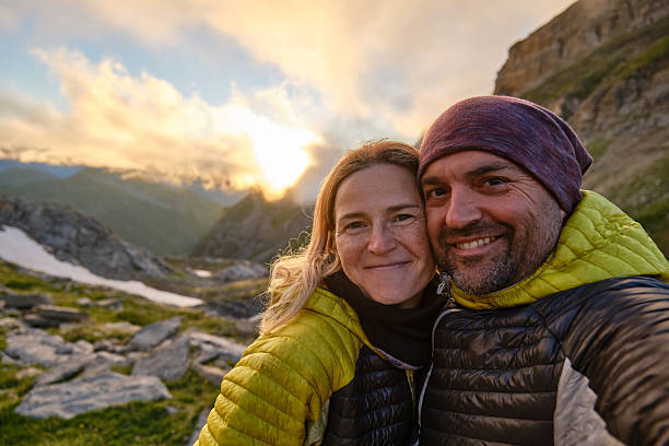 istock Happy couple taking selfie in mountains during sunset 2214503773