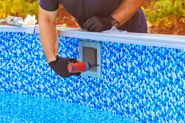 istock Worker performing maintenance on backyard swimming pool in sunny outdoor setting 2214507158