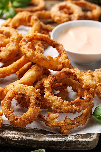 istock Deep fried onion rings on wooden board with sauce 2214513782