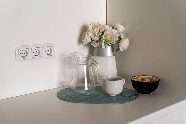 istock Glass jug with cup and flowers on kitchen counter 2214514197