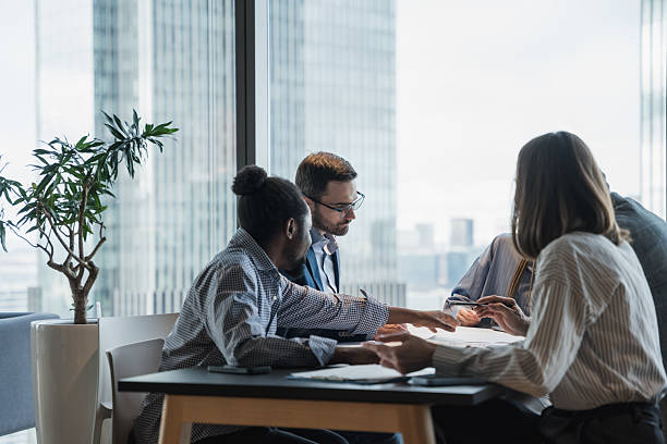 istock Group Of Professionals Collaborating Around a Table in a Bright Office 2214514244
