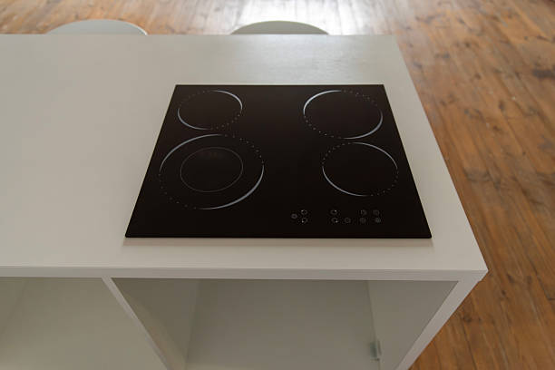 istock Induction hob on a white kitchen island with wooden floor 2214514551