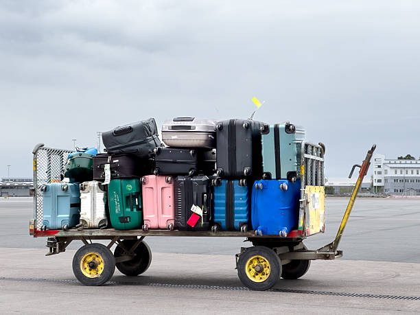 istock Suitcases stacked on baggage trailer at airport 2214517734