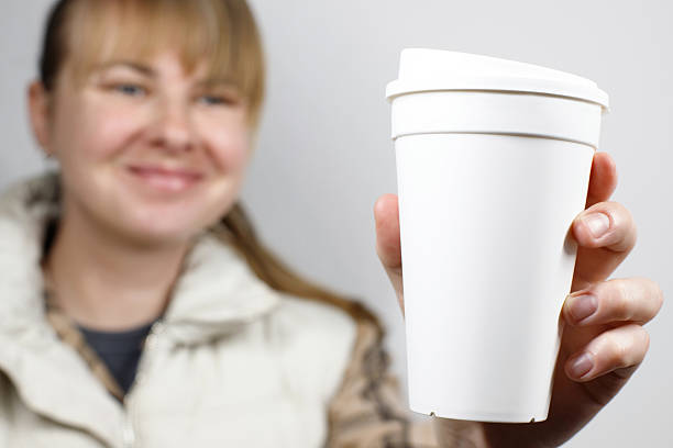 istock Close-up of woman holding compostable drink cup 2214520061