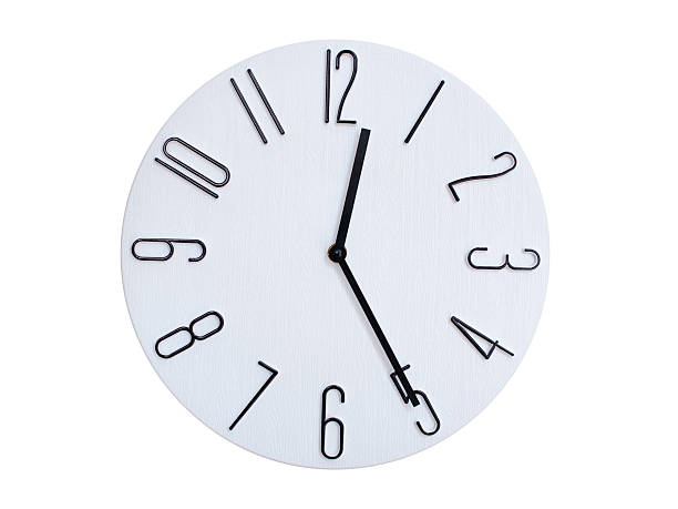 A modern white face with black numbers analog wall clock Showing 00:25 or 12:25. Isolated on White Background.