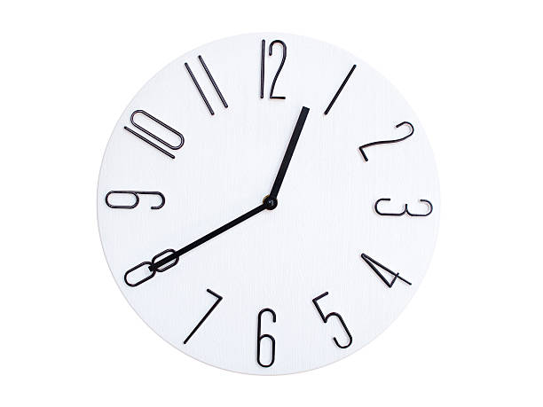 Minimal wall clock with light wood frame and white face displaying 00:40 or 12:40. Perfect for clean, modern concepts about time and scheduling.