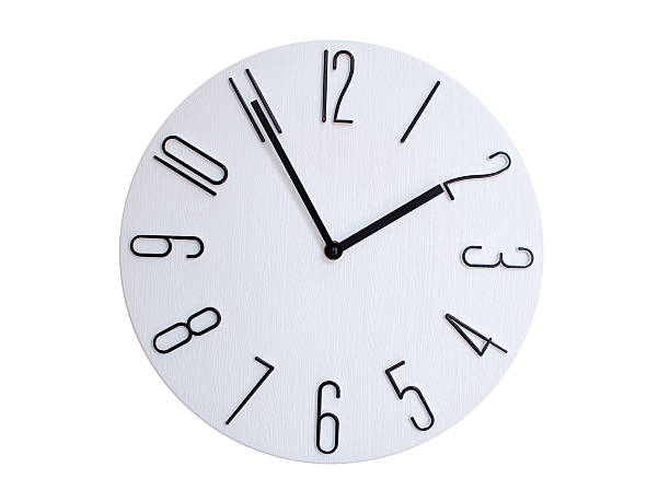 Minimalist Round Wall Clock Showing 01:55 or 13:55. Thin Black Numerals on White Wood Background.