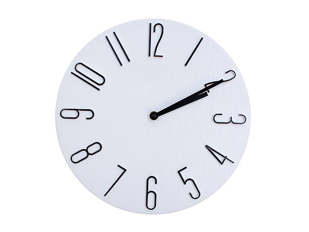 Minimalist Round Wall Clock Showing 02:10 or 14:10. Thin Black Numerals on White Wood Background.