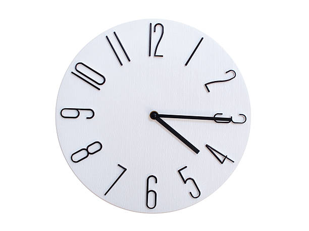 Minimalist Round Wall Clock Showing 04:15 or 16:15. Thin Black Numerals on White Wood Background.