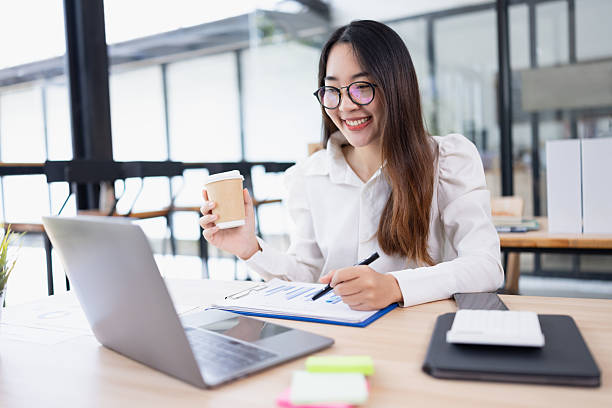 istock Asian female wear eyeglasses using laptop working at desk in office working space. 2214521533