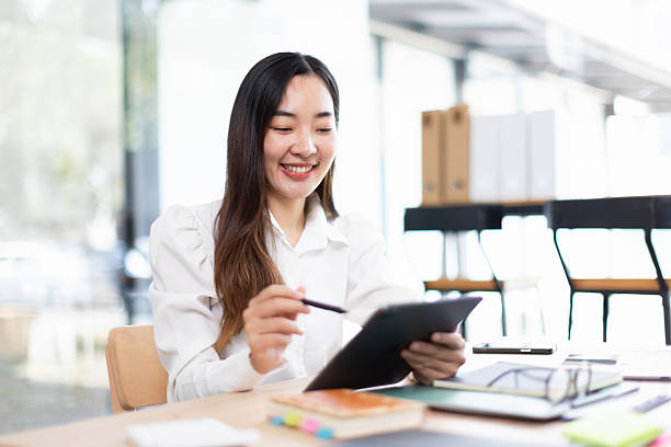 istock Asian businesswoman using tablet with analysis data at desk in office working space, 2214521716