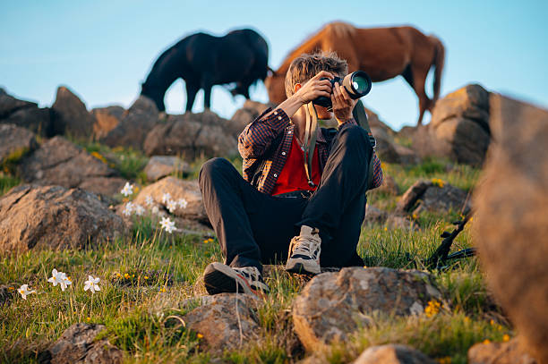 istock Young photographer in nature with wild horses 2214525232