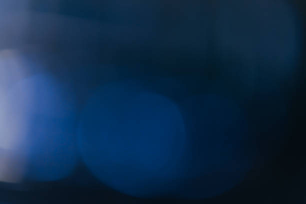 Blue background created in camera with a macro lens with overlapping bokeh circular shapes soft edges light and dark areas with room for copy and text.