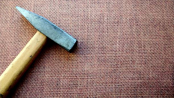 istock A hammer with a wooden handle on a brown surface. 2214529712