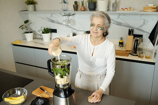 istock Senior Woman Preparing Healthy Smoothie in Modern Kitchen 2214532723