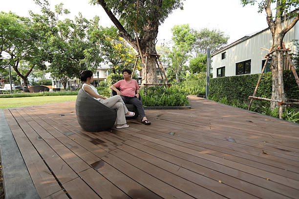 The East Asian couple is sitting and relaxing in the park.