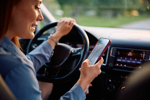 istock Close up of woman looking for direction on online map while driving car. 2214535601