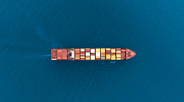 istock Top view Cargo Container ship with contrail in the ocean ship carrying container and running for import export concept technology freight shipping by ship. 2214540448