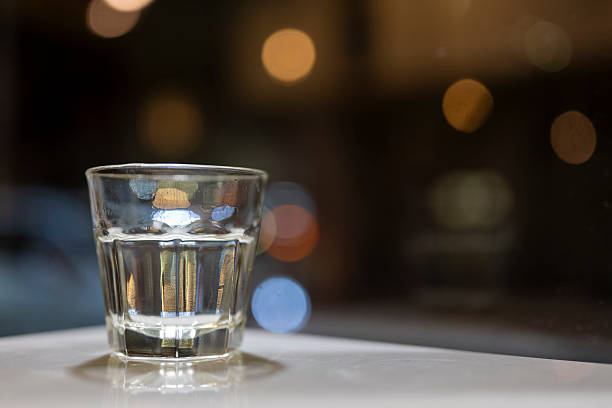 istock A Shot Glass on a Table with Bokeh Lights 2214541875